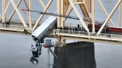 В Америке грузовик едва не упал с моста в реку, но спасателям удалось это предотвратить: видео - Auto24