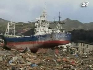 Японцы разыскивают уцелевшие вещи на месте разрушенных домов