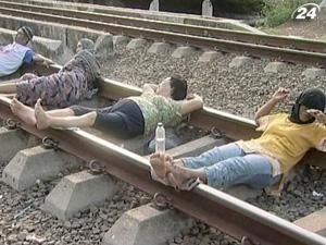 Люди "лечатся" на рельсах, пропуская через себя ток Люди "лечатся" на рельсах, пропуская через себя ток