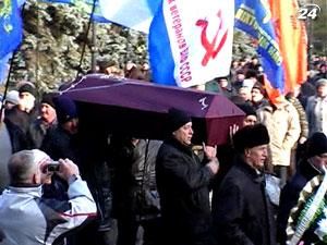 Люди создали бутафорский гроб и пронесли его по центру города Люди создали бутафорский гроб и пронесли его по центру города