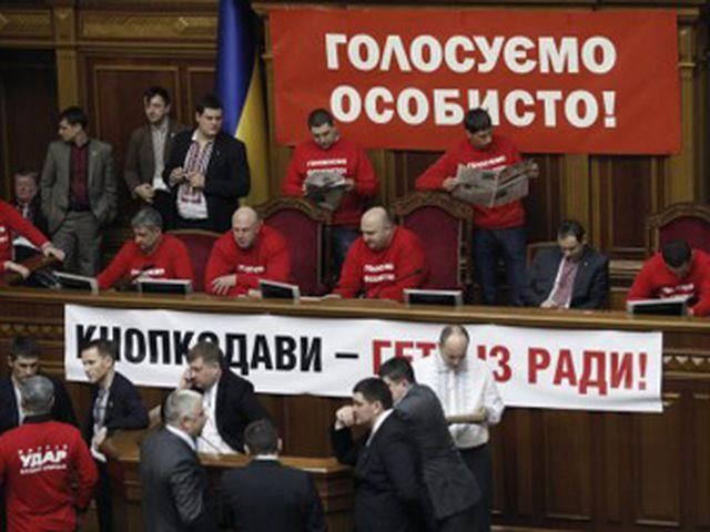 Оппозиция продолжает блокировать парламент, но уже с новыми плакатами