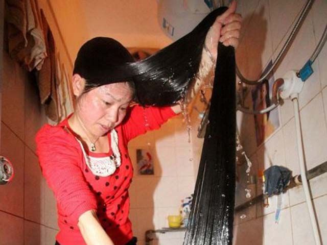 В Китае женщина зависима от собственных волос - ее косы уже достигли 2 метров