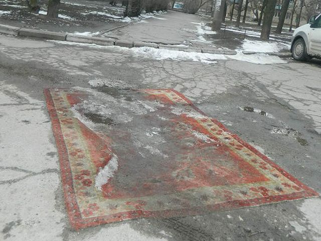 В Запорожье ямы на дорогах застилают коврами (Фото) В Запорожье ямы на дорогах застилают коврами (Фото)