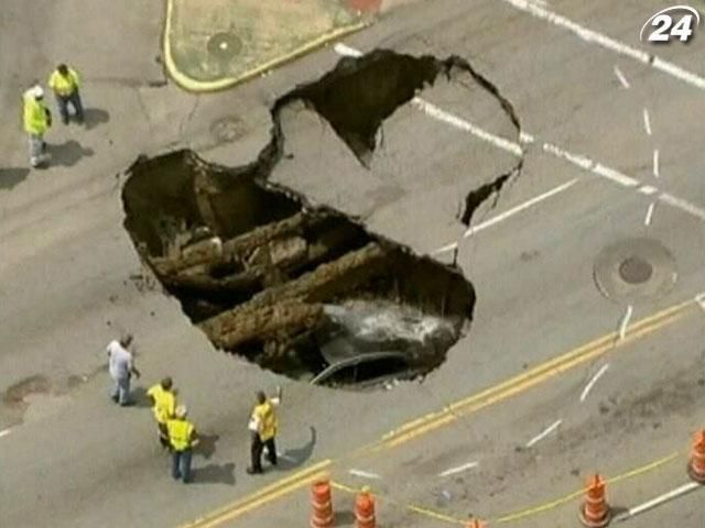 У США автомобіль із водієм упав у велетенську яму на дорозі