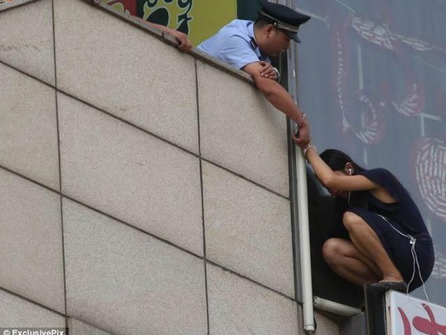 Китайский полицейский спас самоубийцу, приковав себя к ней (Фото)