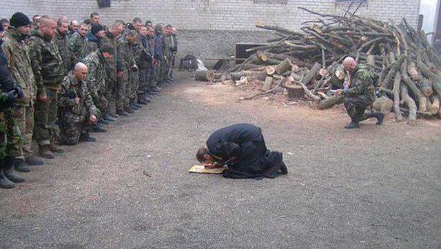 Фото дня: священник стал на колени перед героями АТО