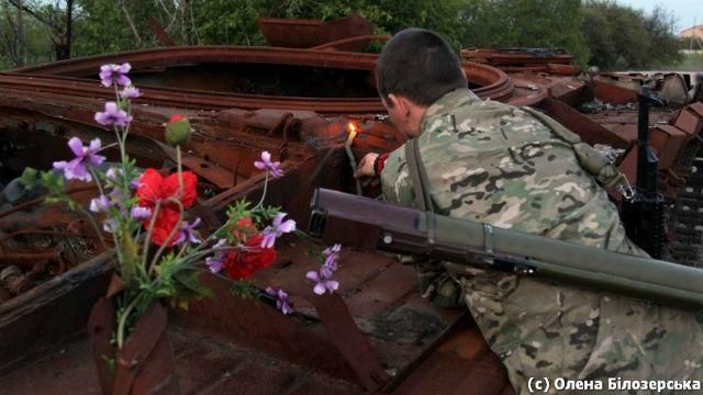 Фото дня. До обгорілого танку,  де загинули 5 бійців, постійно несуть квіти