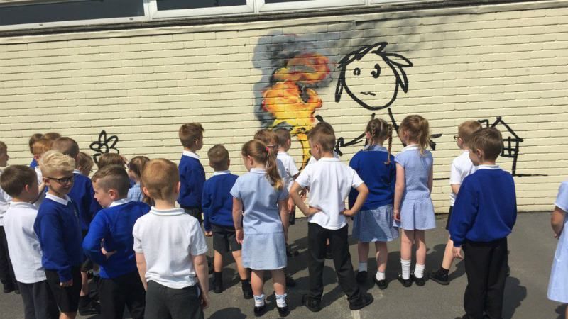 Бенксі здивував новим малюнком: на стіні школи з'явилась палаюча шина