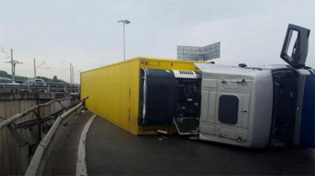 Грузовик перевернулся и свисает с моста в Киеве