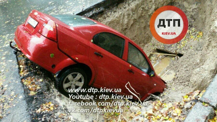 Посреди дороги в Киеве автомобиль провалился в яму