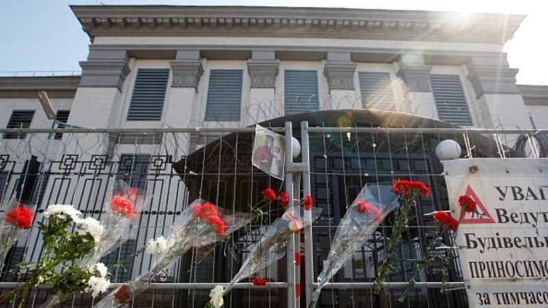 Одиночные цветы в кривом заборе: под посольством РФ в Киеве тоже выражают соболезнования