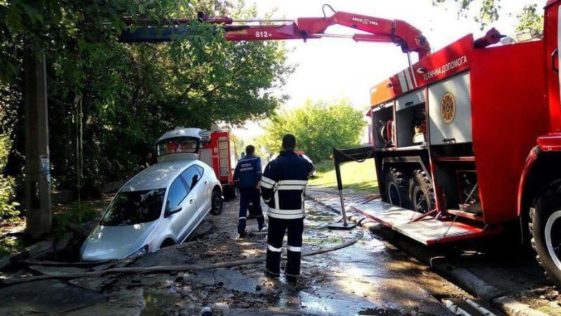 Через прорив труби у Києві автомобіль провалився під асфальт Через прорив труби у Києві автомобіль провалився під асфальт