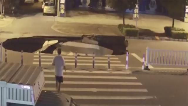 Водій скутера провалився у величезну діру посеред дороги у Китаї: відео