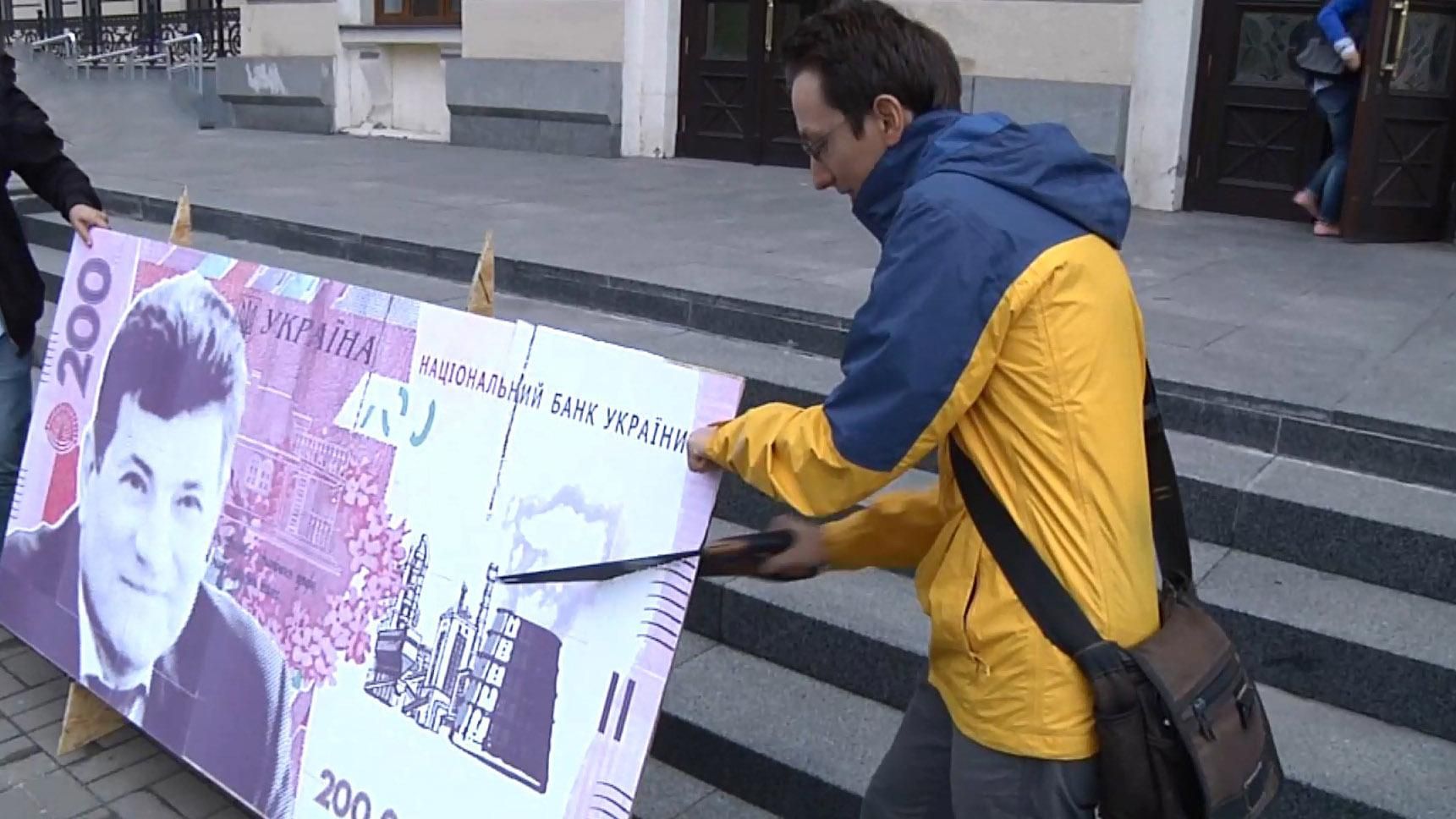В Запорожье активисты распилили бутафорскую банкноту с фотографией городского головы
