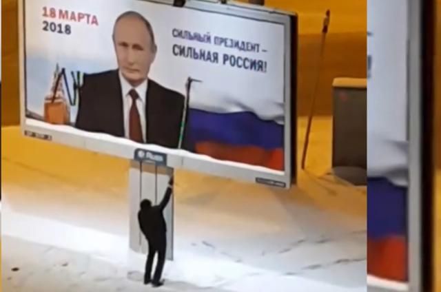 "Брехун": у Росії чоловік розмалював білборд із портретом Путіна (відео)