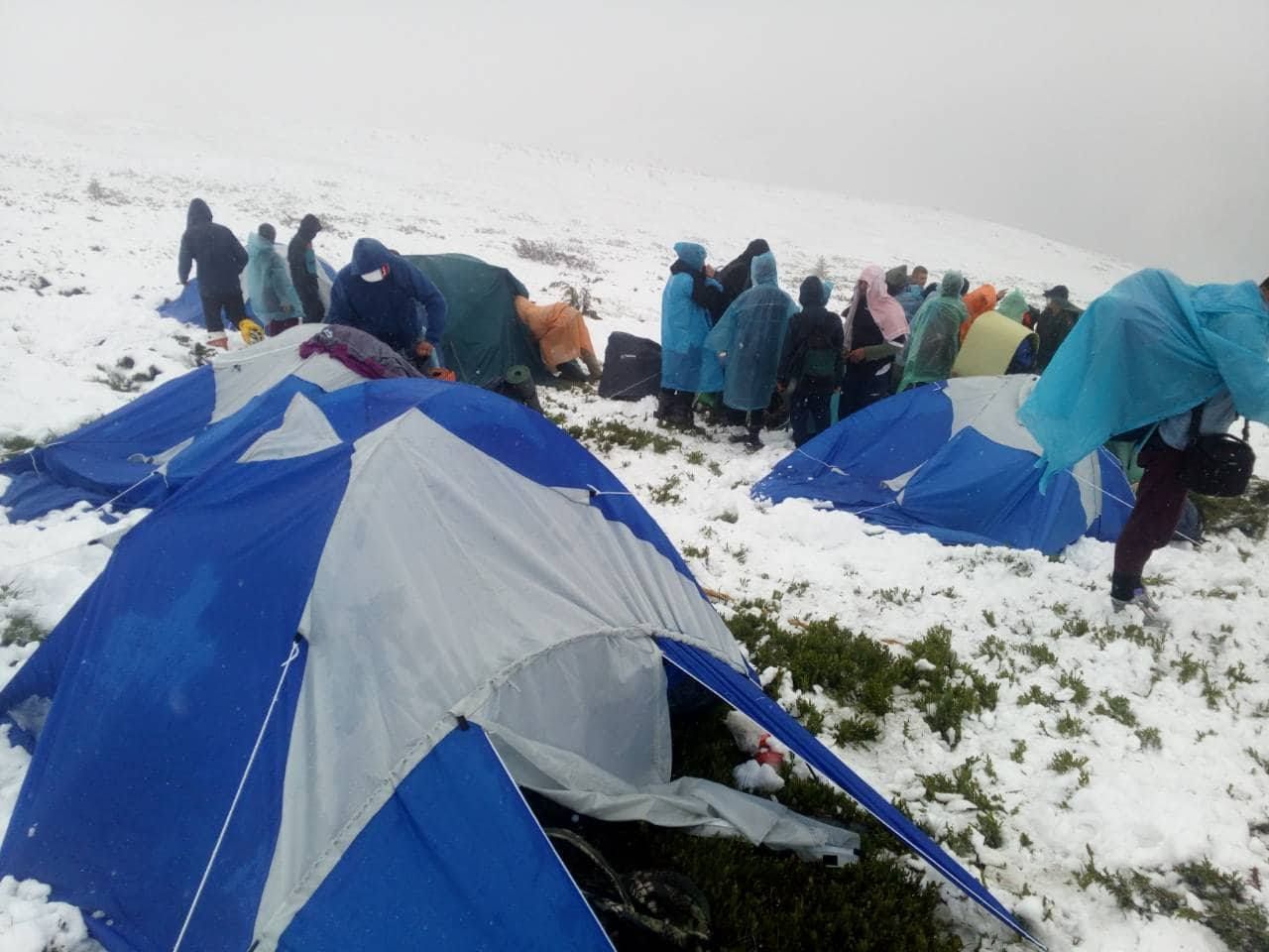 У дощовиках посеред засніжених гір: рятувальники добралися до дитячого табору в Карпатах (фото)