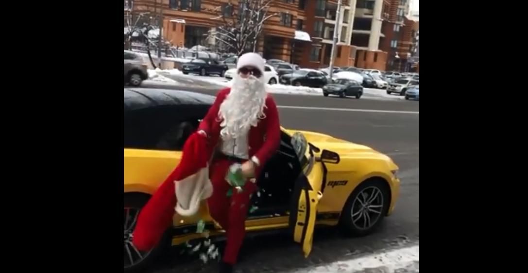 На кабріолеті з відкидним верхом: у Києві стильний Санта Клаус роздавав людям цукерки – відео