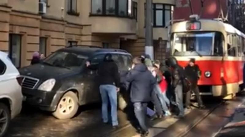 У Києві роздратовані люди посунули з дороги автомобілі, що заблокували трамвай: відео У Києві роздратовані люди посунули з дороги автомобілі, що заблокували трамвай: відео