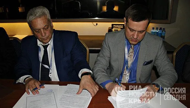 Дмитро Сташків (праворуч)підписує контракт / Фото РиаНовости