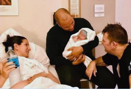 Тіматті Кофі зі своїм партнером та дитиною, народженою від сурогатної матері