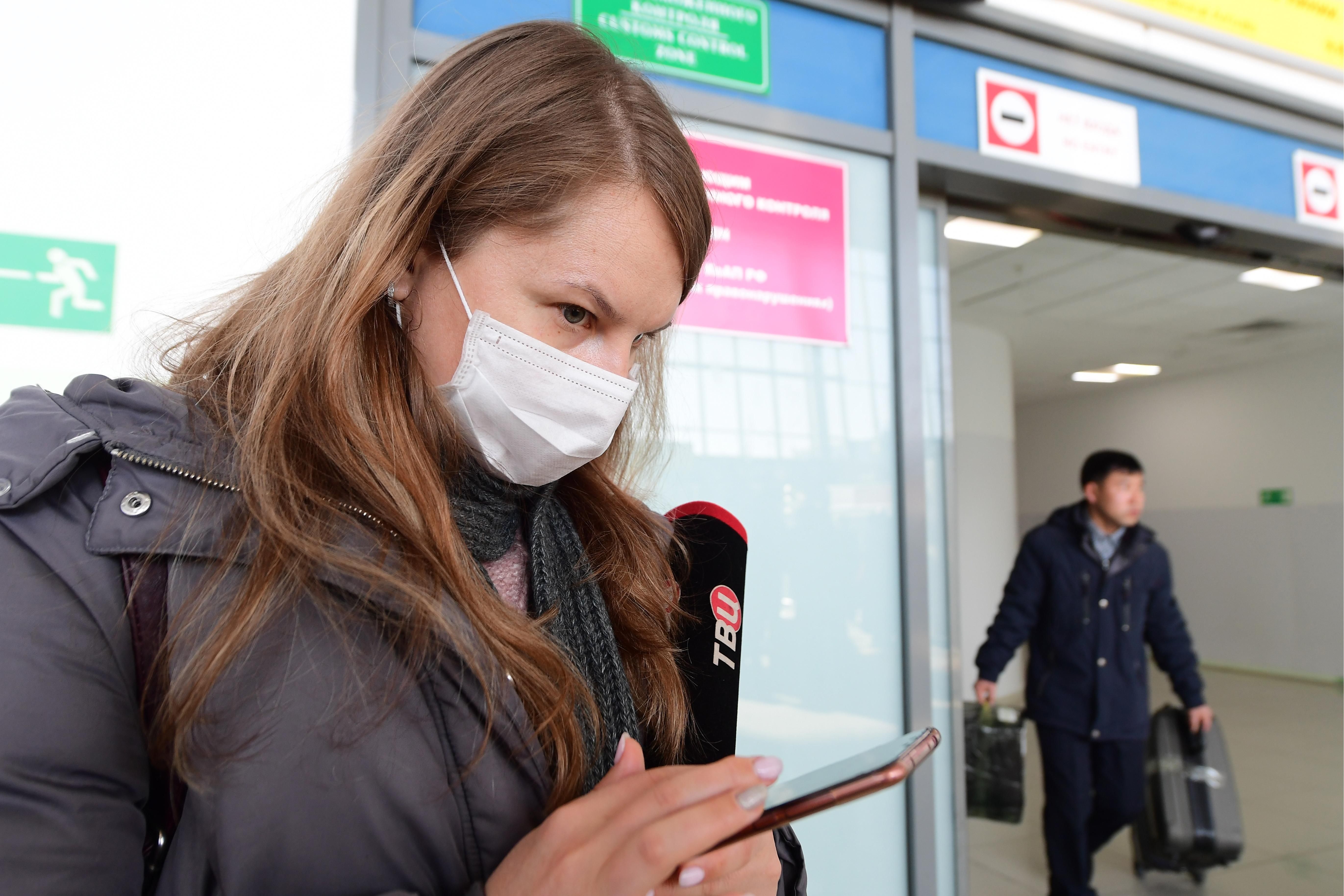 Девушка в маске в аэропорту Владивостока, Россия