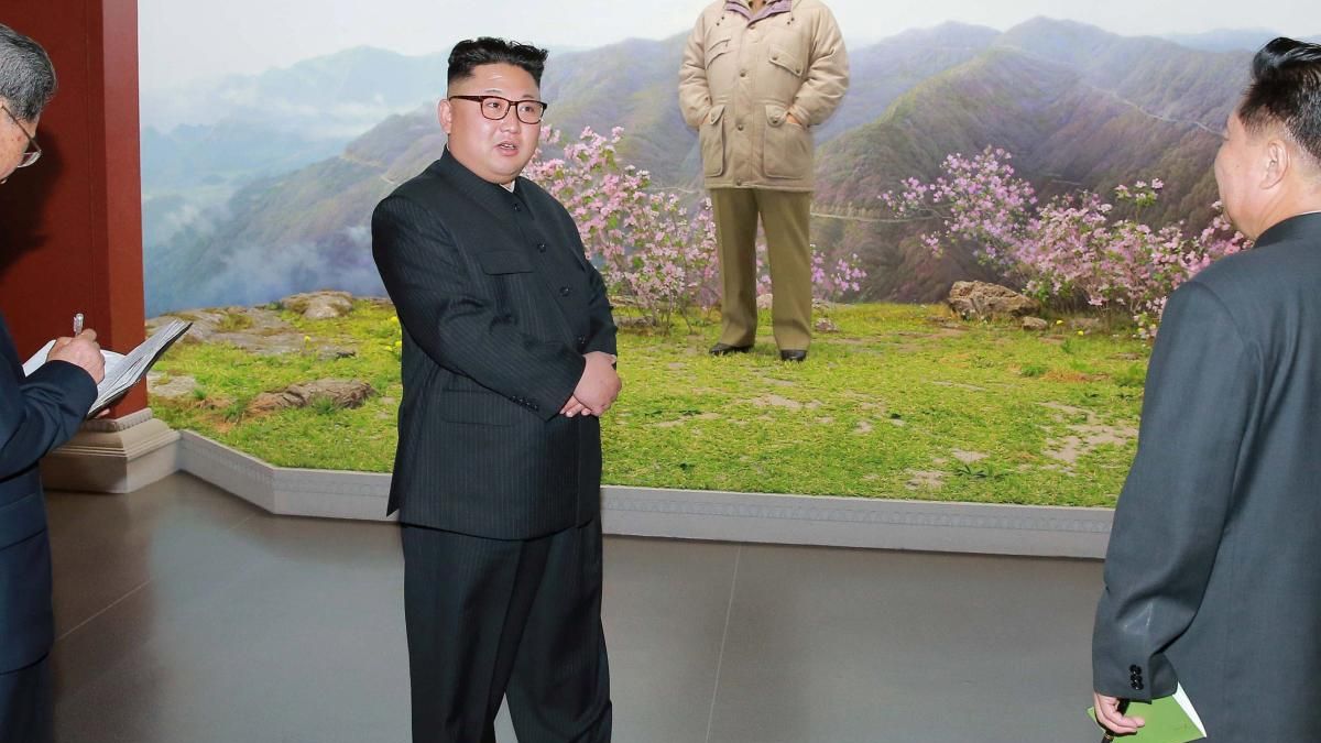 Ким Чен Ын на фоне портрета отца