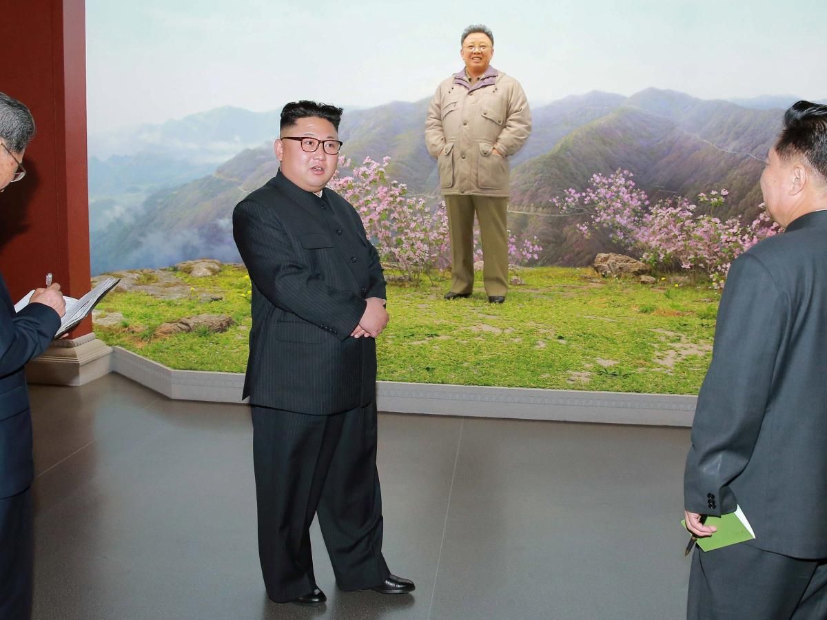 Ким Чен Ын на фоне портрета отца