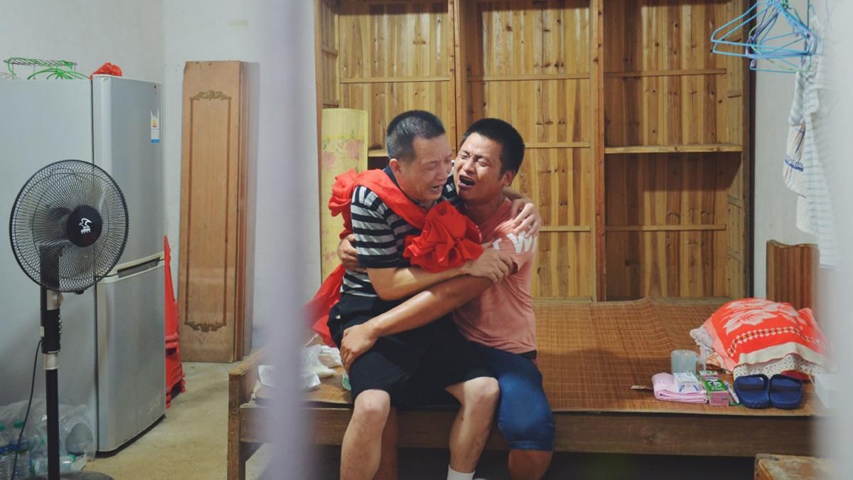 Чжан разом з сином плачуть у себе вдома в місті Няньчан, провінція Цзянсі. Чжан разом з сином плачуть у себе вдома в місті Няньчан, провінція Цзянсі.