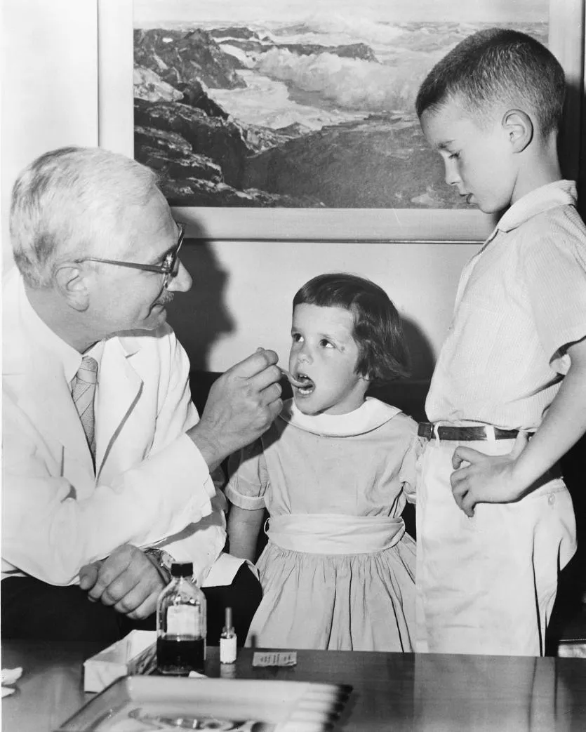 ​Альберт Сабін демонструє, як дітям роблять пероральну вакцину проти поліомієліту