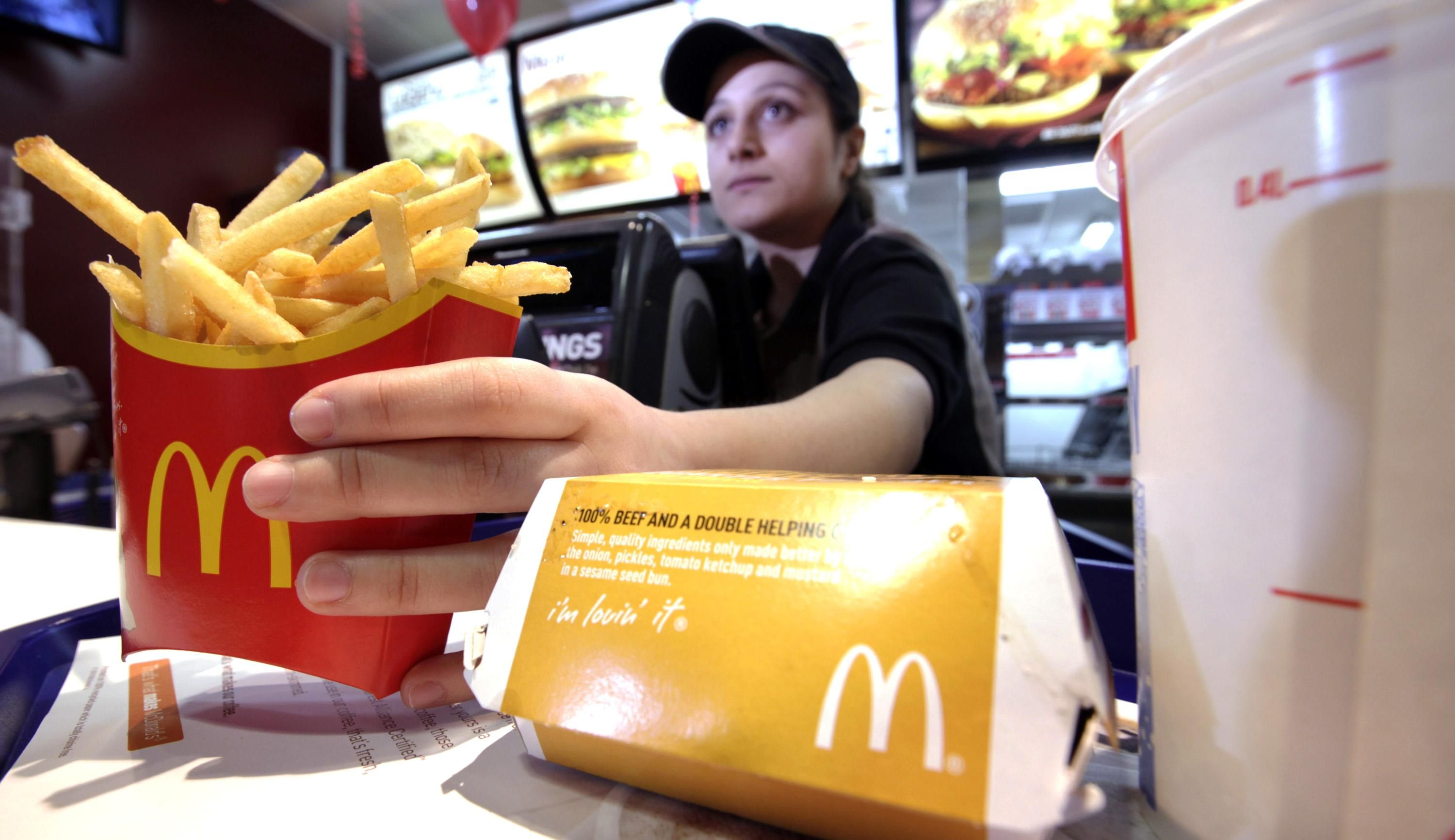 Работница McDonald's  выдает заказ