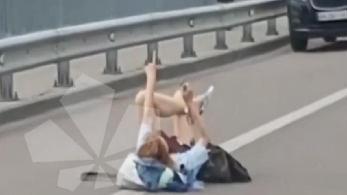 В Киеве возле Гидропарка девушка разлеглась посреди дороги В Киеве возле Гидропарка девушка разлеглась посреди дороги