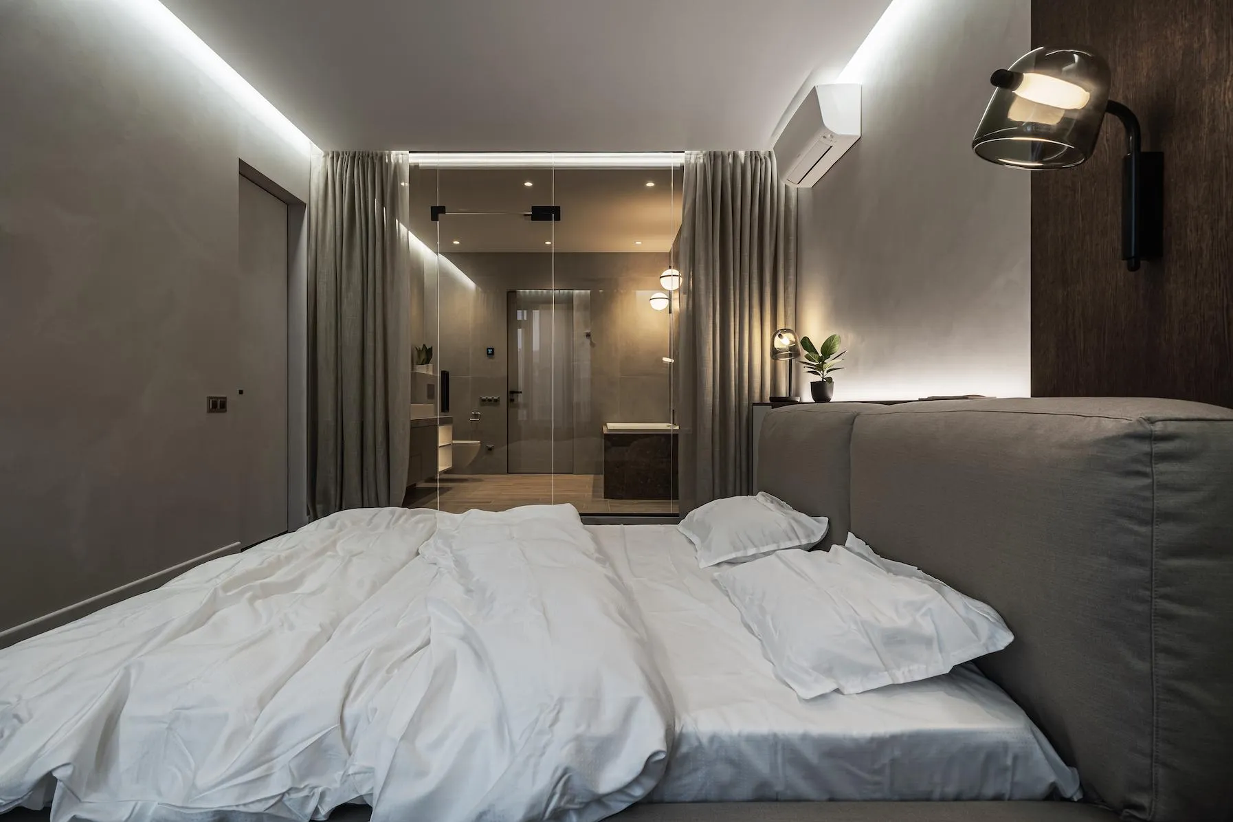 Прозора стіна в ванну кімнату нагадує вікно і візуально розширює простір спальні Прозора стіна в ванну кімнату нагадує вікно і візуально розширює простір спальні