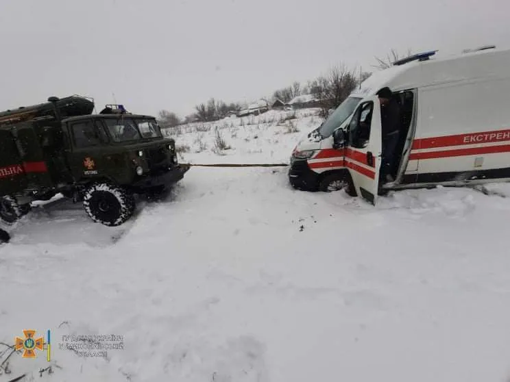 Рятувальники допомагають швидкій вибратися із снігового замету