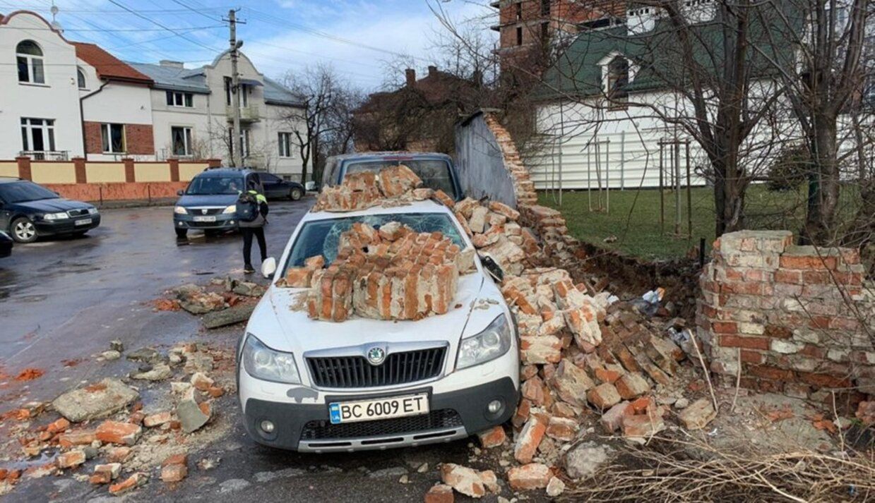 Ветер во Львове посрывал фасады домов и повалил бетонный забор: фото последствий