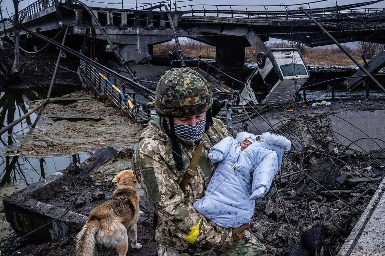 Фото дня: военный несет ребенка у разрушенного моста в Ирпене - 24 Канал