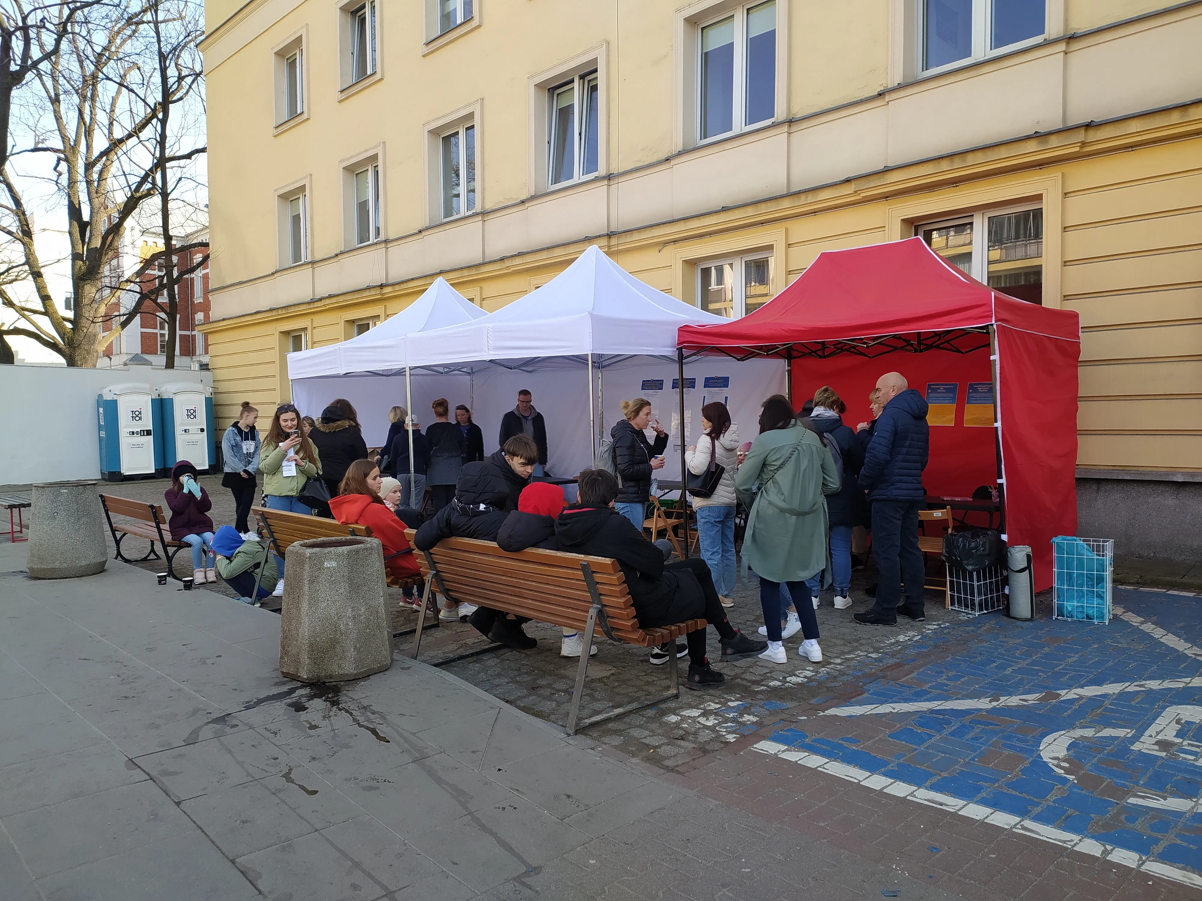 Українців, які стоять у черзі, ужонд частує гарячими напоями та канапками Українців, які стоять у черзі, ужонд частує гарячими напоями та канапками