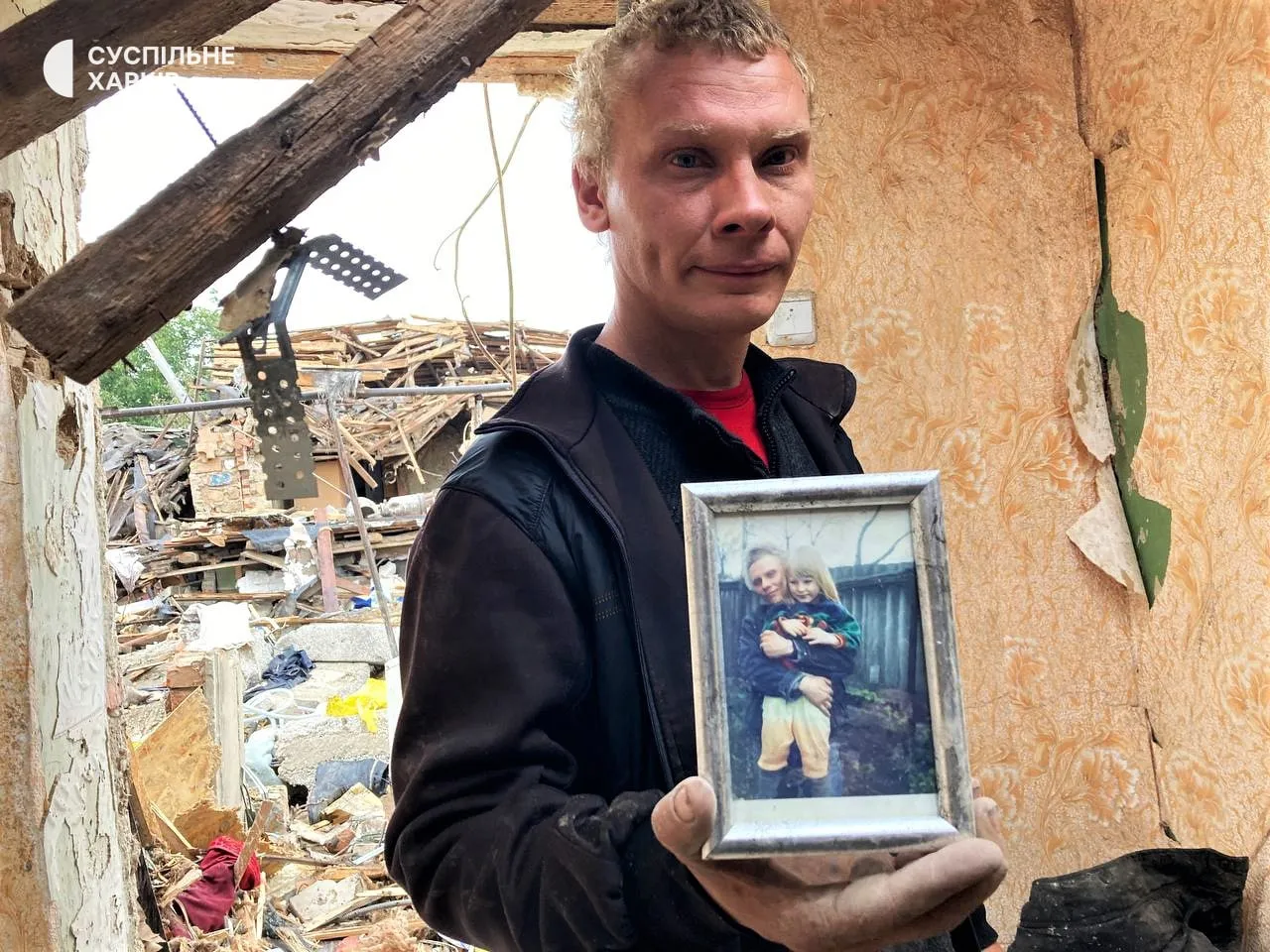 Отец с фото дочери, погибшей в Первомайске