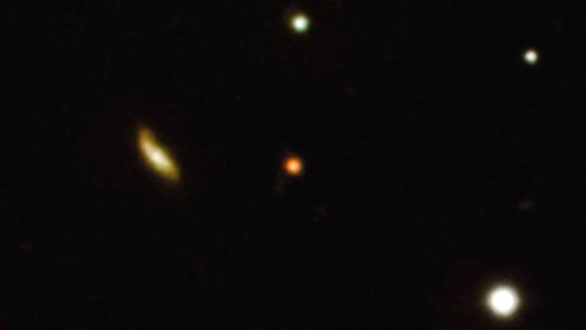 Далекий гамма-спалах (червона пляма в центрі зображення) Далекий гамма-спалах (червона пляма в центрі зображення)