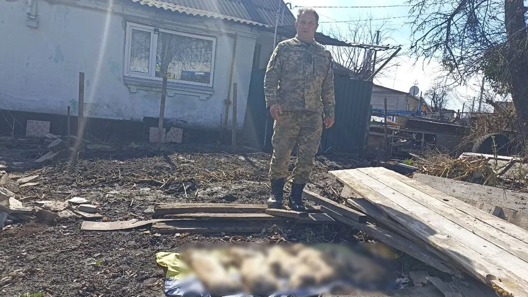 Олег Остапенко  показує мертвих цуценят, яких виявив у себе на городі