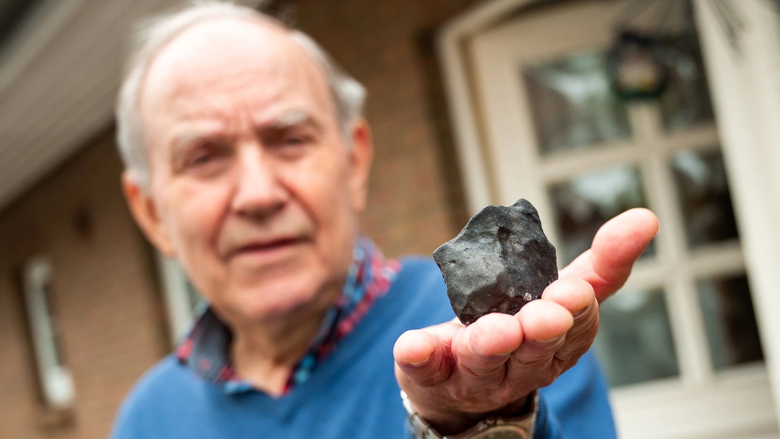 Домовладелец Вильфрид Лабуш с маленьким метеоритом, упавшим на его дом Домовладелец Вильфрид Лабуш с маленьким метеоритом, упавшим на его дом