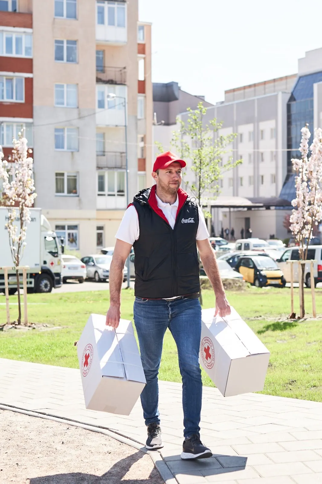 Работники компании Кока-Кола переносят коробки с постельными комплектами в помещение. Работники компании Кока-Кола переносят коробки с постельными комплектами в помещение.