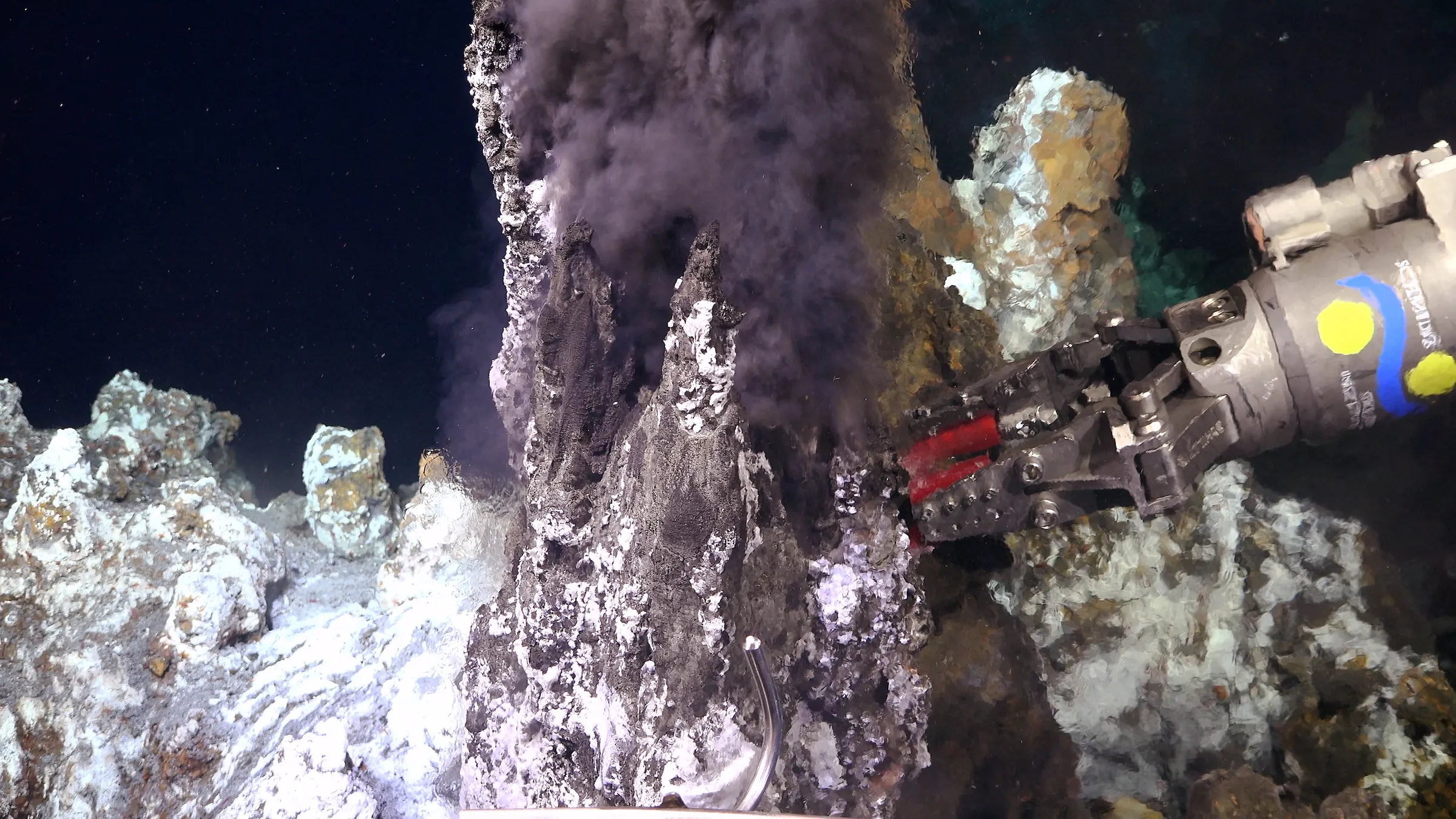 Подводный робот берет геологический образец из гидротермального жерла