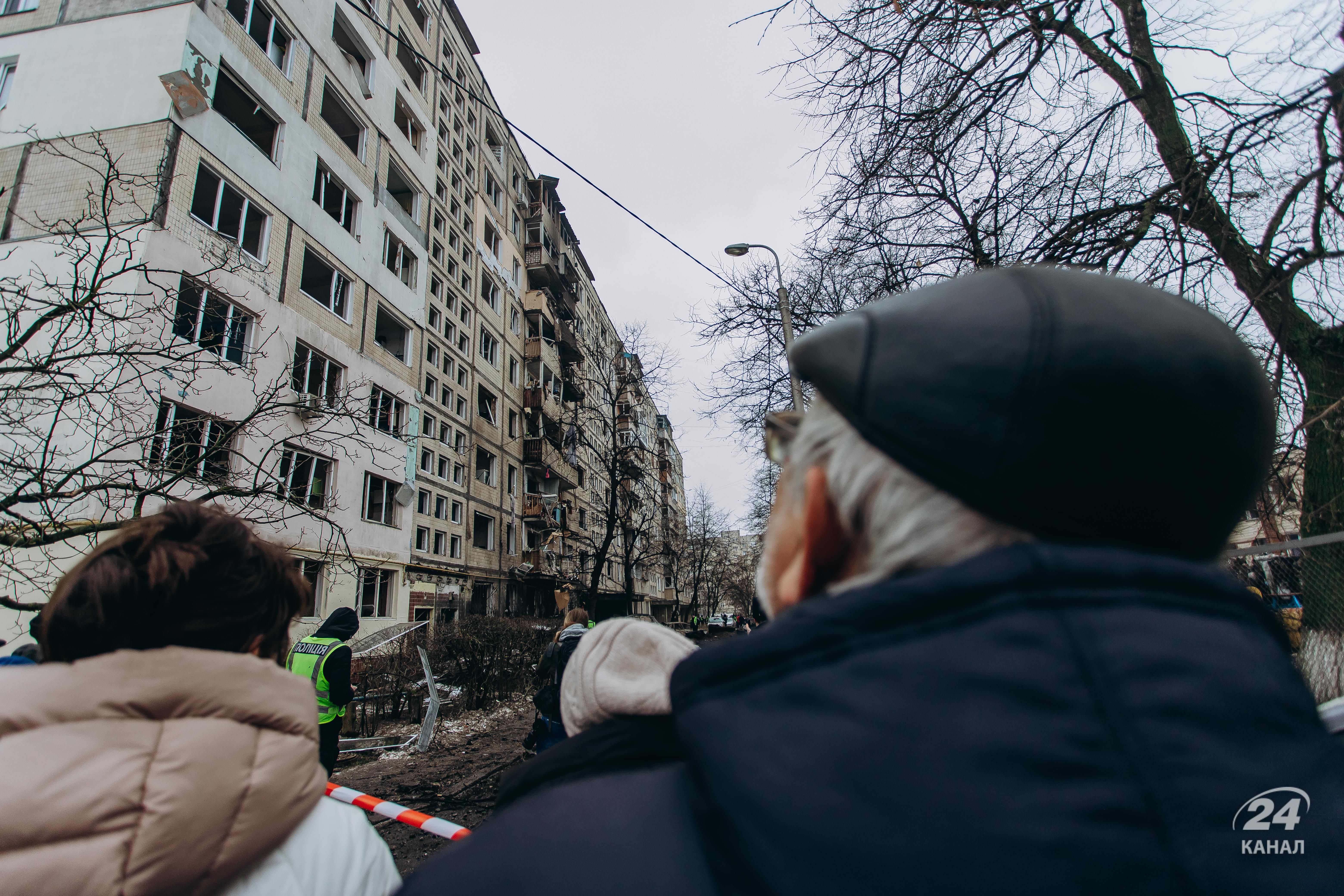 Киевляне смотрят на дом, пораженный ракетой 13 декабря 2023