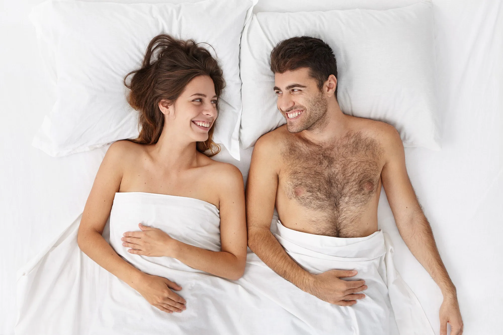Пара после секса счастливая лежит в постели