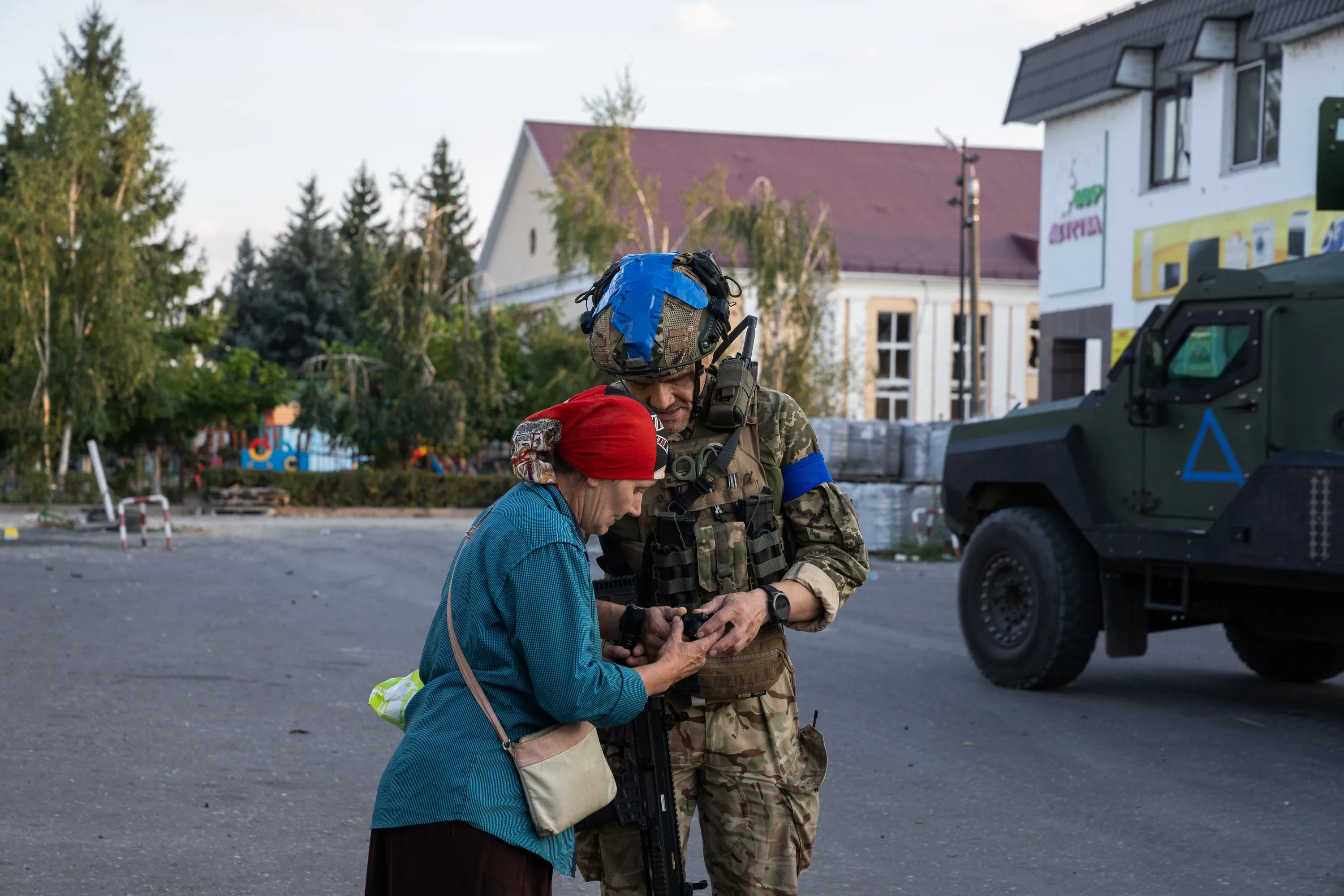 Військовий допомагає росіянці у Суджі