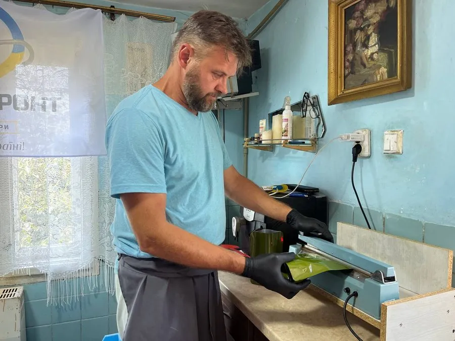 Чоловік вакуумує пакет Чоловік вакуумує пакет