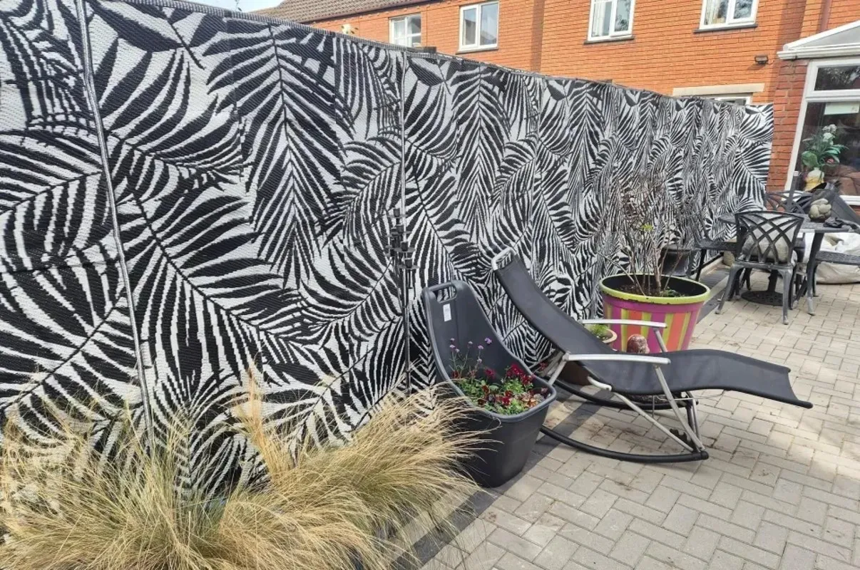 Женщина обновила забор коврами Женщина обновила забор коврами