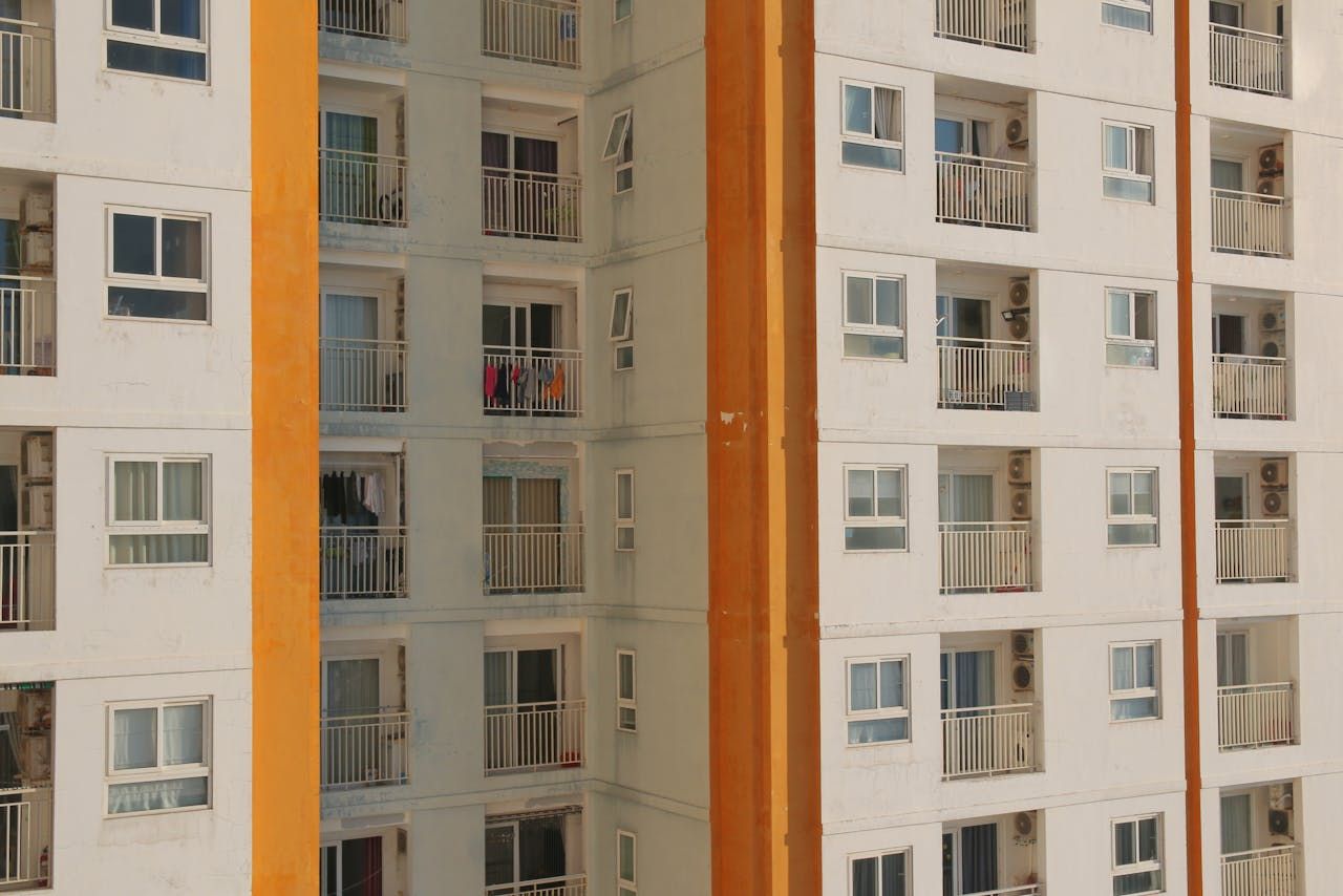 Многоквартирный жилой дом, имеет белый фасад с оранжевым Многоквартирный жилой дом, имеет белый фасад с оранжевым