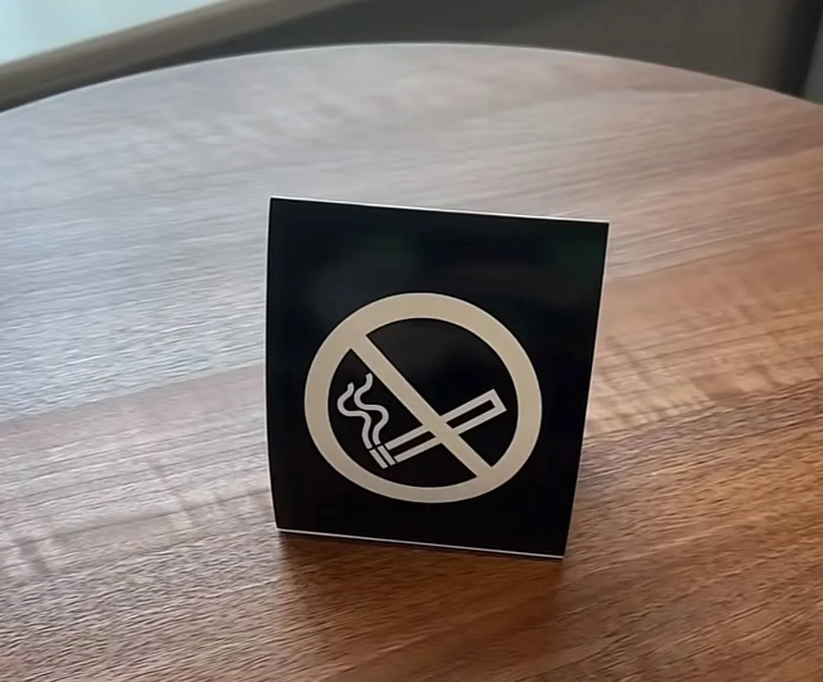 Табличка о запрете курения на деревянном столе Табличка о запрете курения на деревянном столе