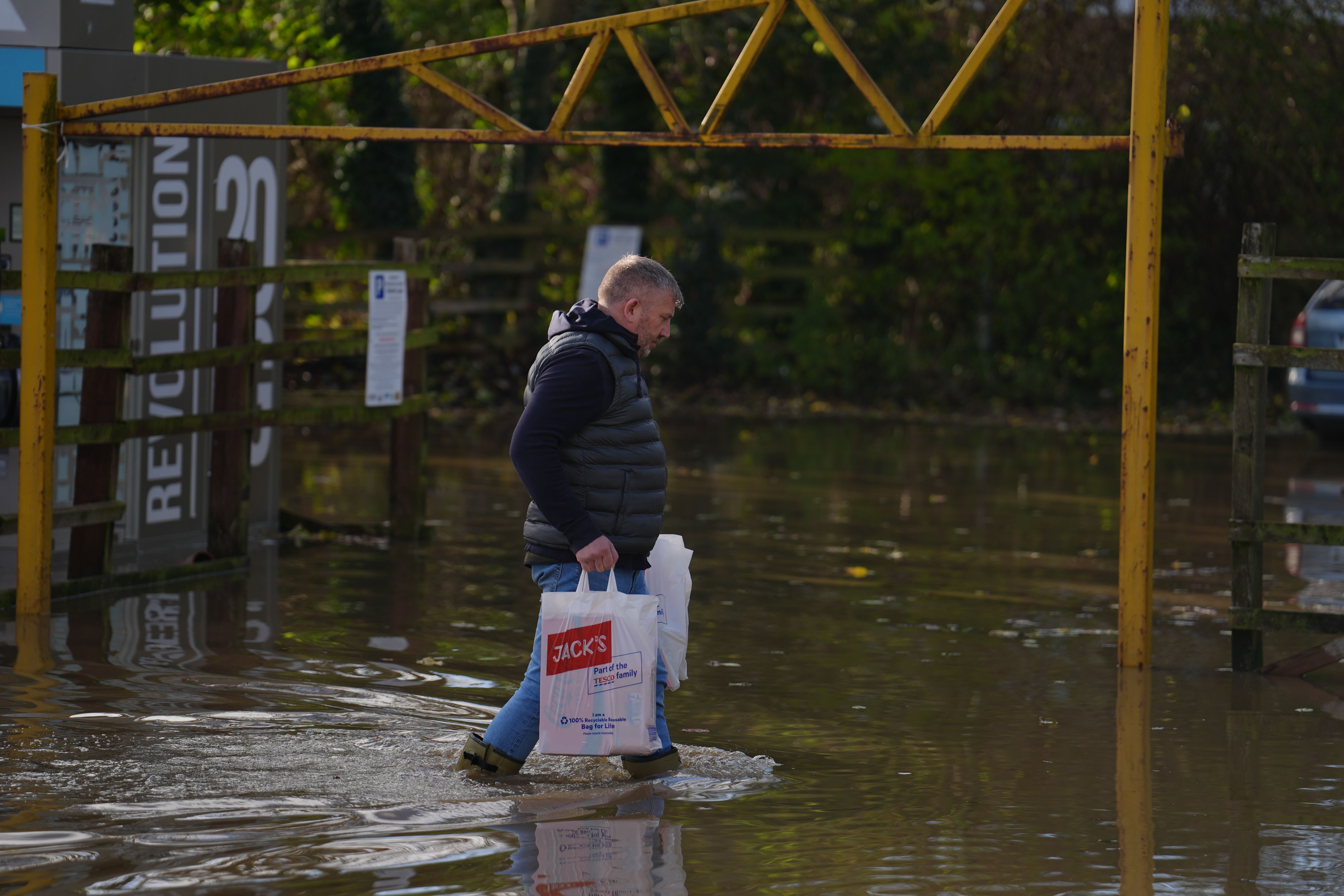 Мужчина идет в воде во время наводнения из-за шторма Берт Мужчина идет в воде во время наводнения из-за шторма Берт